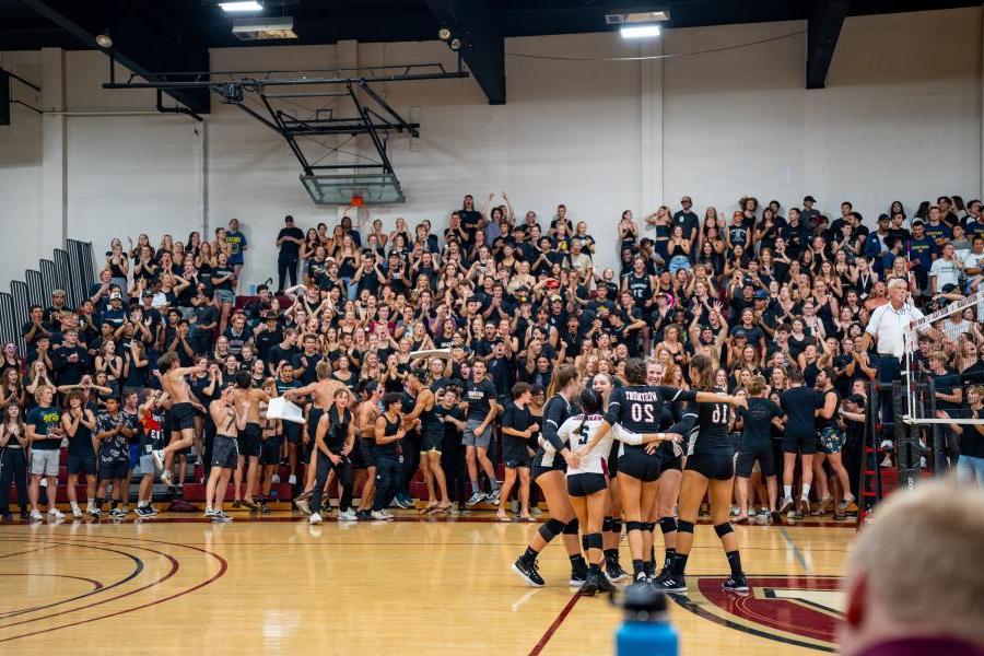 Women's volleyball celebrates during a blackout game